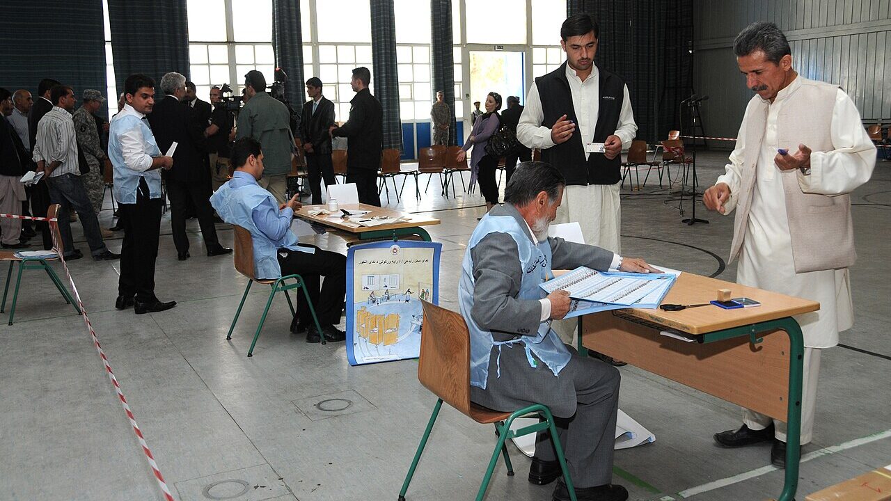 Voters at a polling station completing ballots at tables