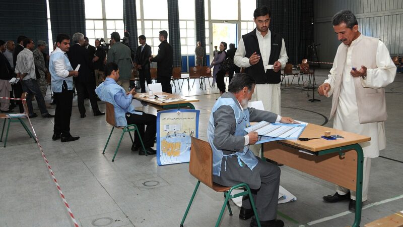 Voters at a polling station completing ballots at tables