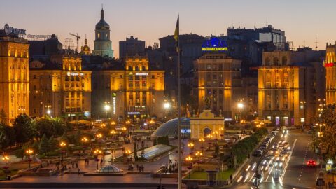 Kyiv city centre at dusk with illuminated historic buildings and traffic