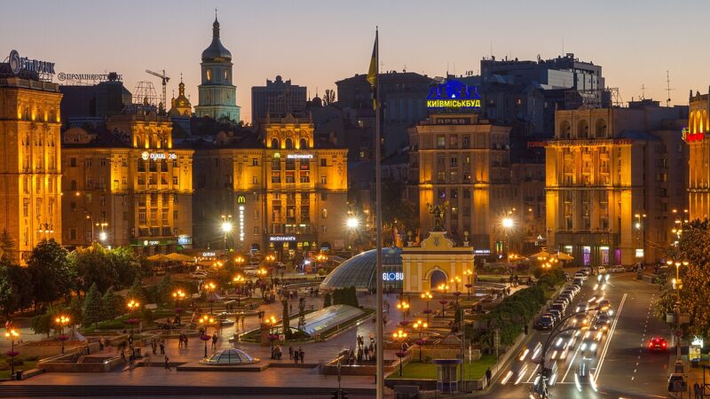 Kyiv city centre at dusk with illuminated historic buildings and traffic