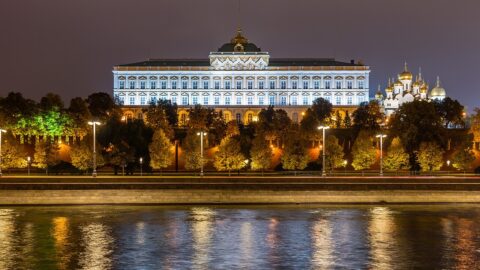 Kremlin building illuminated at night beside a river