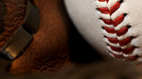 Baseball resting in a leather glove